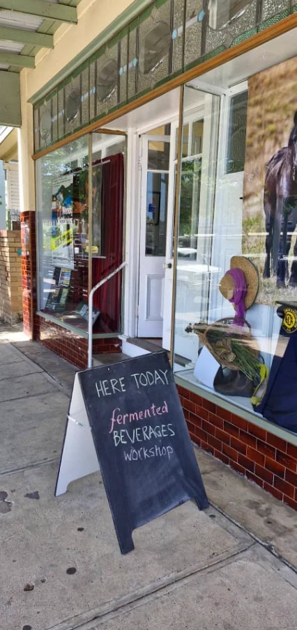 Storefront with A-frame sign advertising a fermented beverages workshop held today