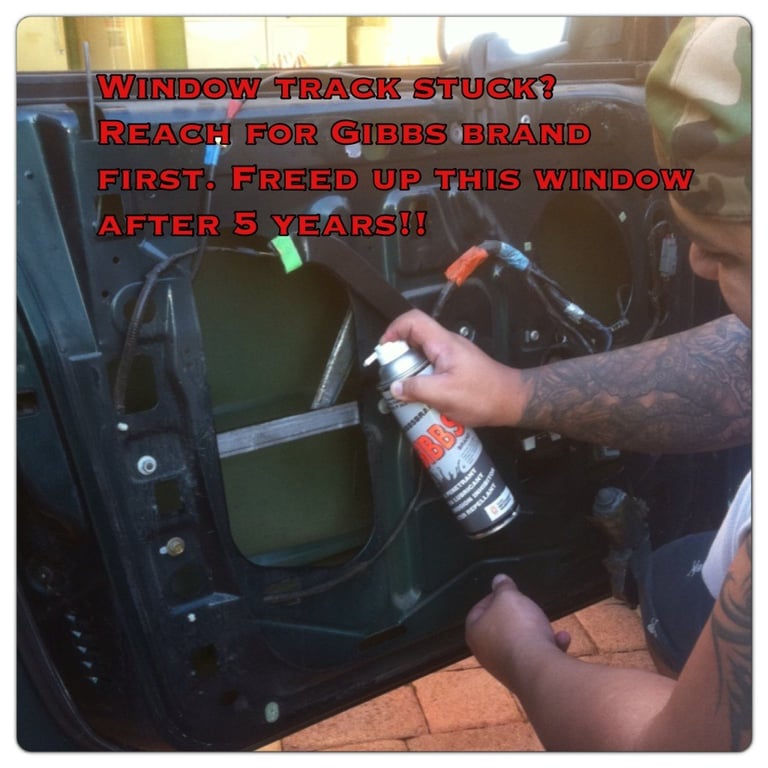 Person applying Gibbs Brand lubricant spray to a stuck car window track for maintenance