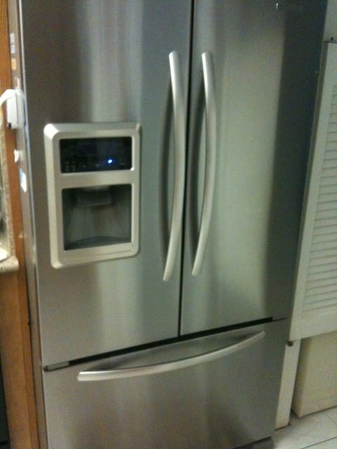 Stainless steel French-door refrigerator with ice and water dispenser on the front panel