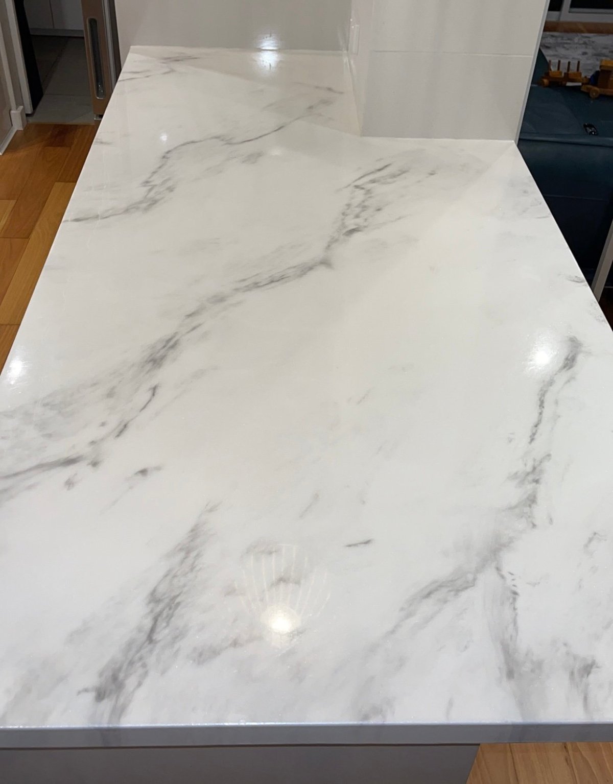 White marble-effect epoxy benchtop and splashback with grey veining in a modern kitchen