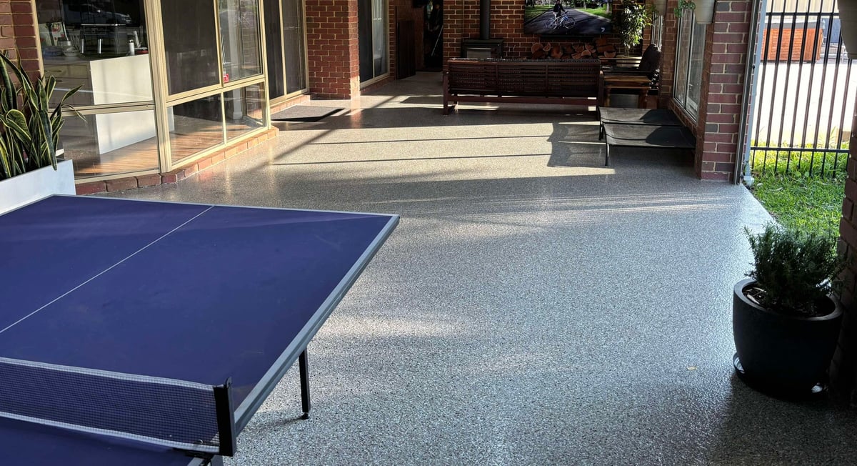 Outdoor alfresco with blue ping pong table on a polished speckled epoxy floor