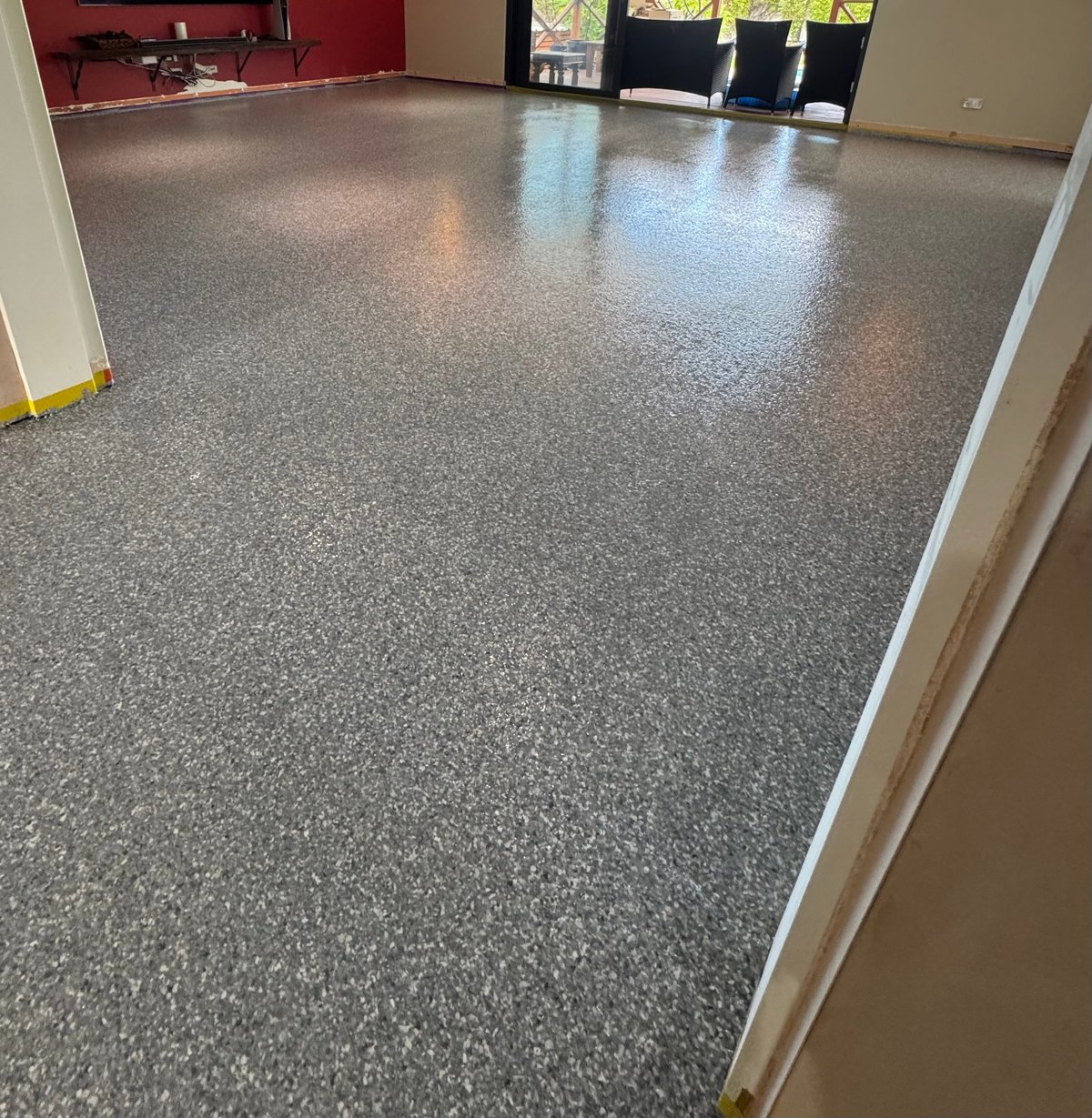 Empty interior with a polished grey speckled flake floor and bright overhead lighting