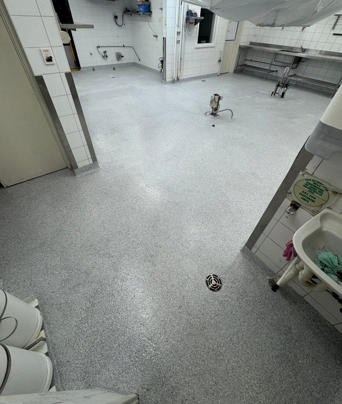 Public amenities with a fresh light grey speckled flake epoxy floor and white fixtures