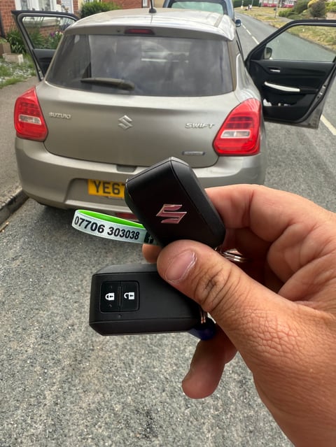 Suzuki Swift in beige/gold parked on a driveway in Scarborough. A new car key is held up in the foreground on a green Scarborough Auto Locksmith lanyard.