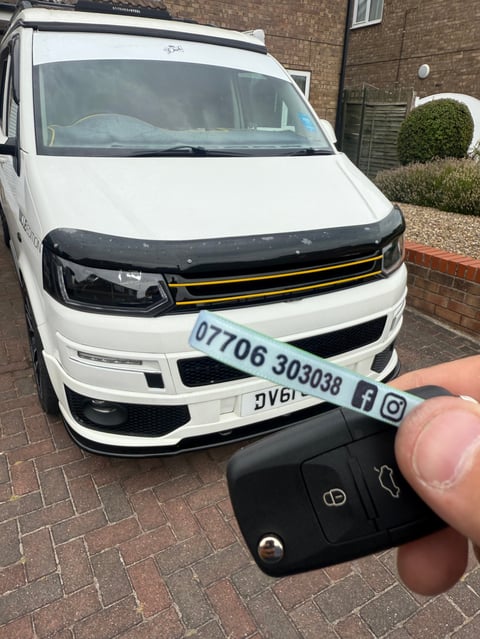 White VW Transporter T6 LWB on a brick driveway in Scarborough. A new VW remote key is held in the foreground on a green Scarborough Auto Locksmith lanyard.