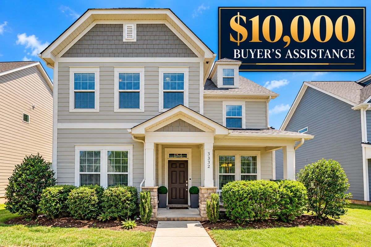 Two-story gray house with black door and $10,000 buyer's assistance offer overlay against blue sky and green lawn