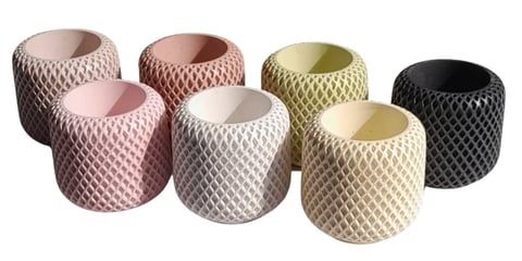 Seven decorative cylindrical planters in varying colors including pink, beige, olive, and black with quilted diamond texture patterns