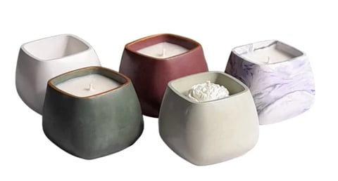 Five decorative candles in various colors and textures including marble, burgundy, sage green, cream, and white finishes