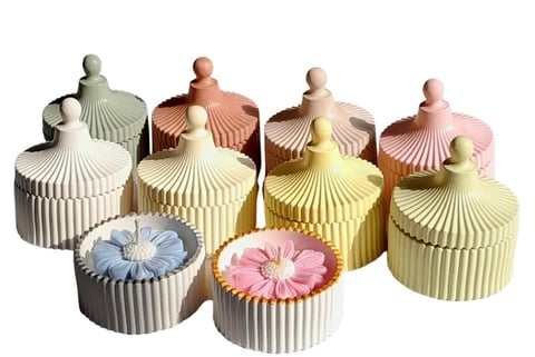 Collection of decorative trinket boxes with ribbed floral lids in various pastel colors and ceramic finials on white background