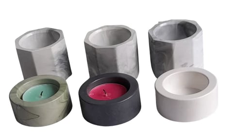 Three concrete candle holders with removable clear glass tops, featuring lit candles in turquoise, magenta, and white
