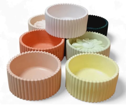 Collection of colorful ribbed ceramic bowls in various sizes and pastel colors arranged in a group display