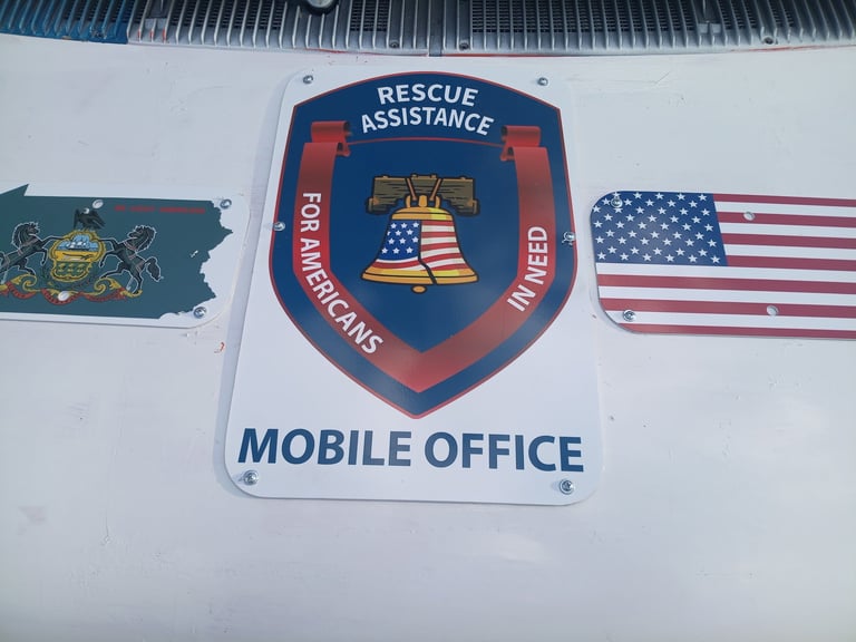 Rescue Assistance Mobile Office sign with blue shield emblem and American flag on white vehicle exterior