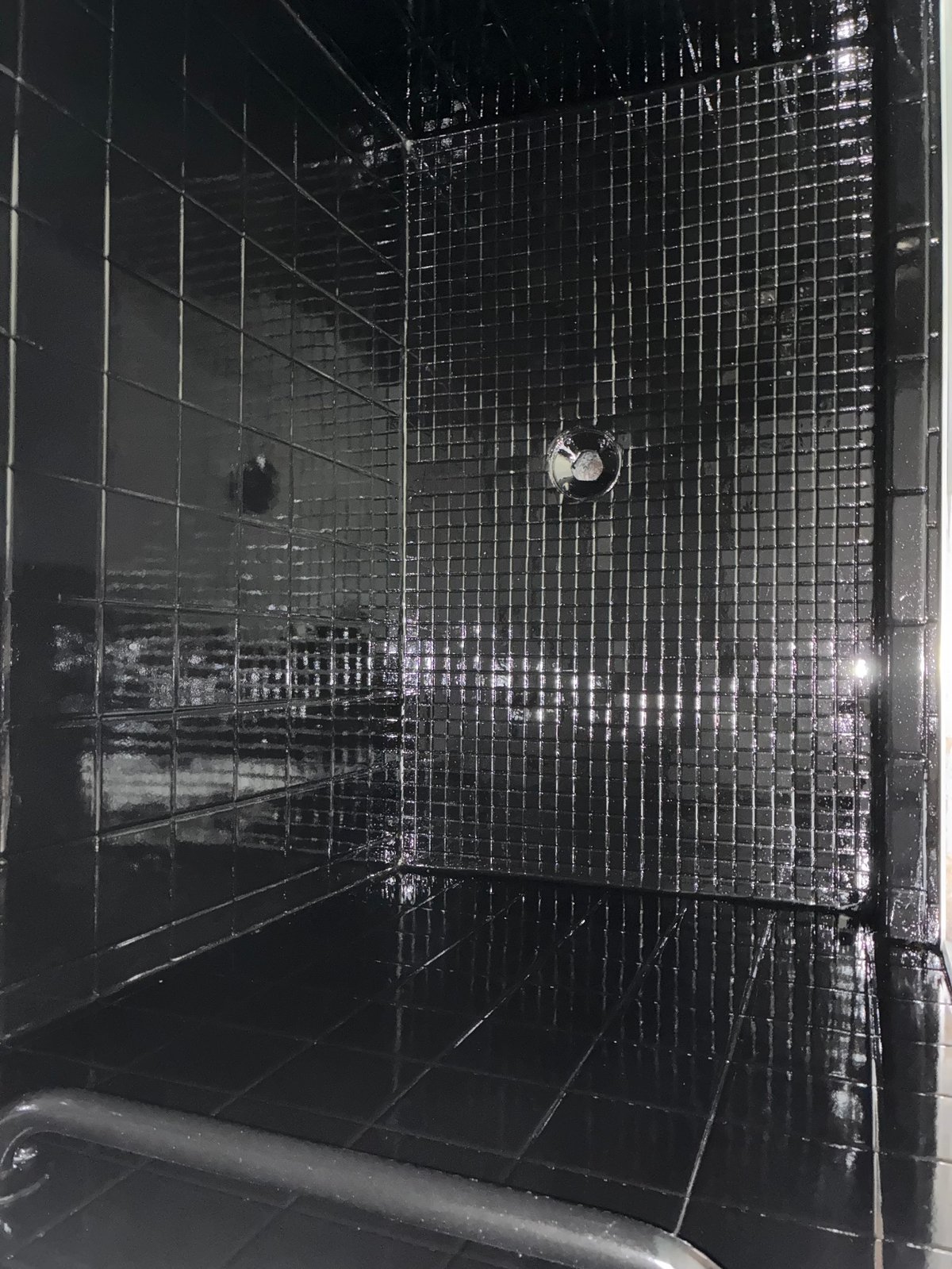 Modern black tile shower enclosure with metallic mosaic wall accents and chrome fixtures after resurfacing