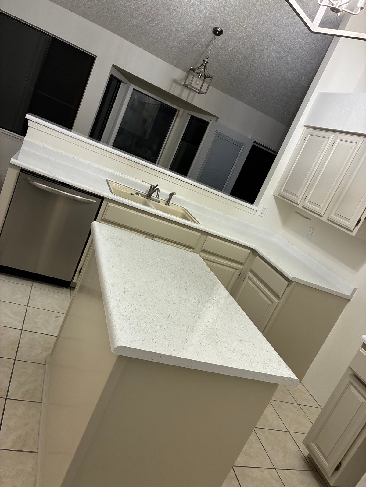 Modern kitchen with refinished white countertops, stainless steel appliances, and gray cabinetry