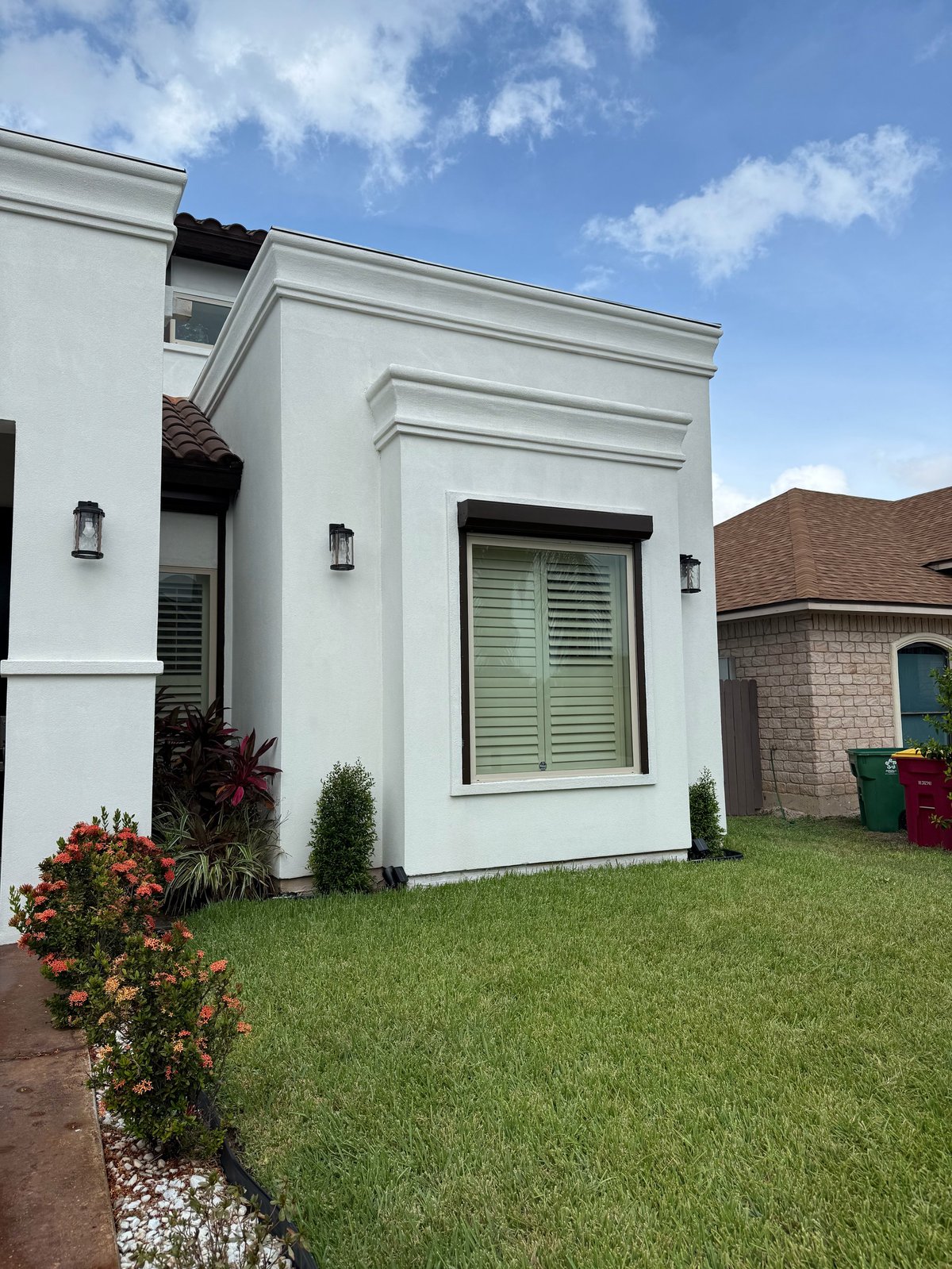 After: modern white house with green shuttered windows and manicured lawn, sparkling clean after soft wash
