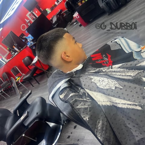 Young person sitting in a car interior with a red and black themed venue or store in the background
