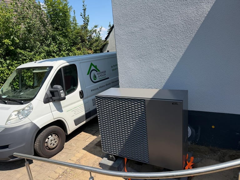 White service van parked next to a modern heat pump unit against a gray building wall