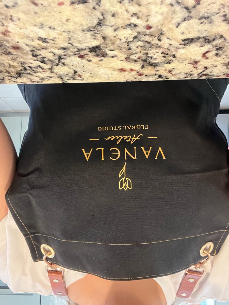 Black backpack with gold text reading Vancida and Floral Studio with decorative handles