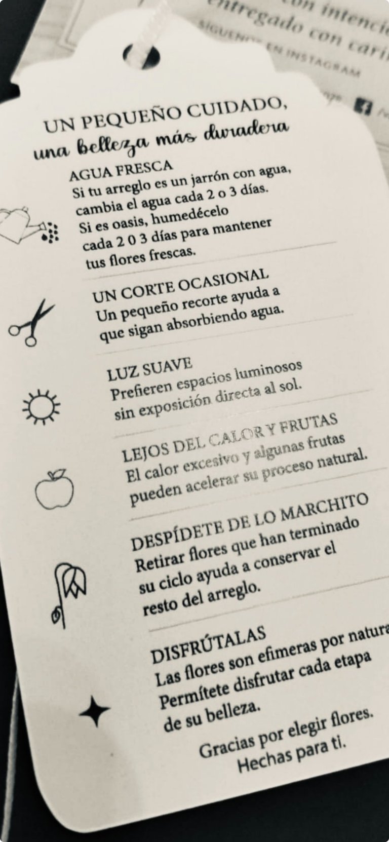 Spanish care instructions tag for fresh flowers with illustrated icons showing watering, trimming, light, and temperature guidelines