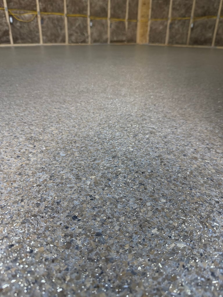 Close-up of a polished concrete floor with a grid window in the background showing a textured stone or aggregate surface