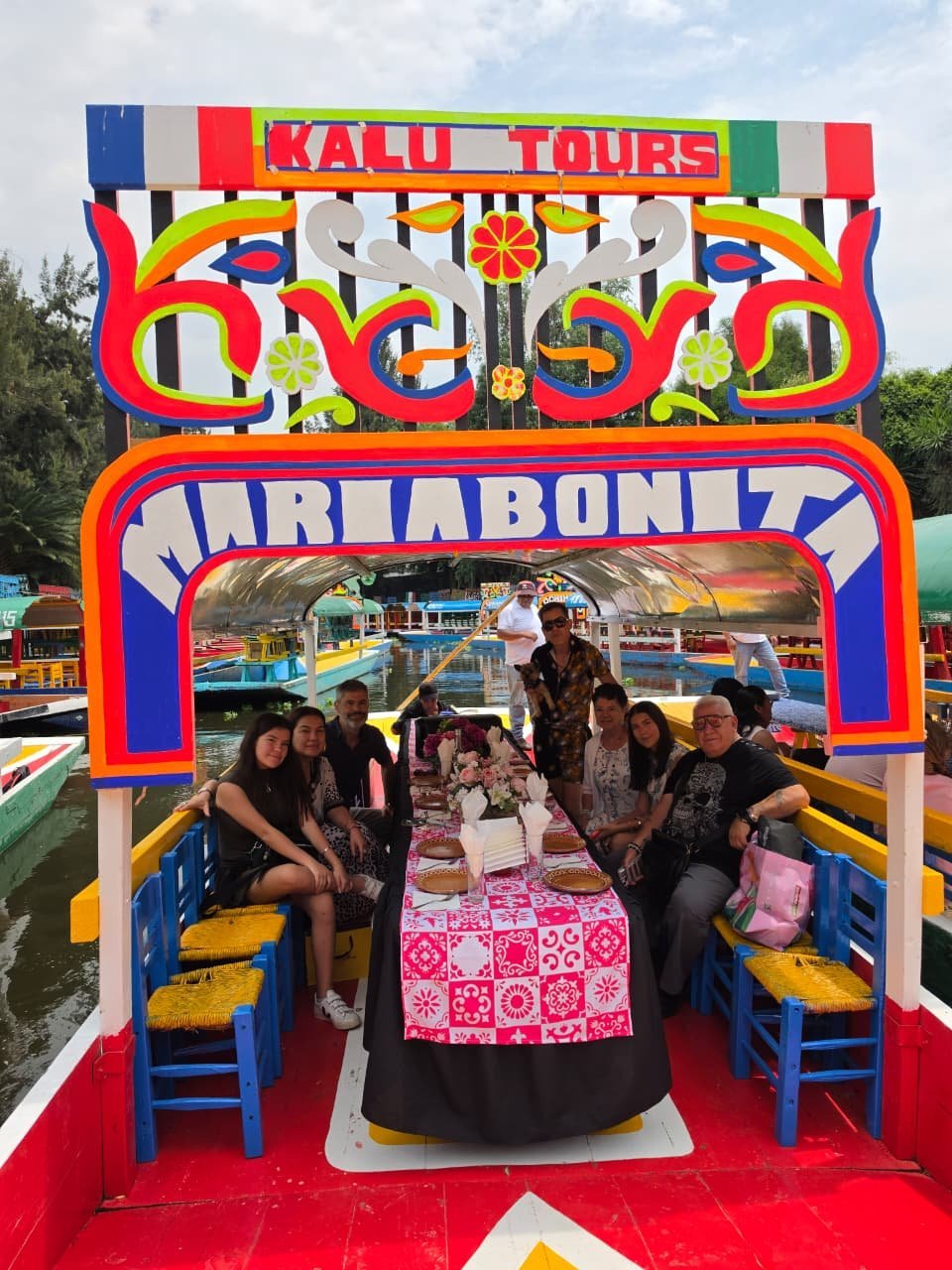 Grupo de personas disfrutando en una trajinera colorida de Kalu Tours en los canales de Xochimilco