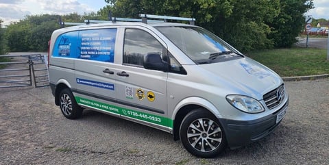 White service van with blue branding parked on gravel