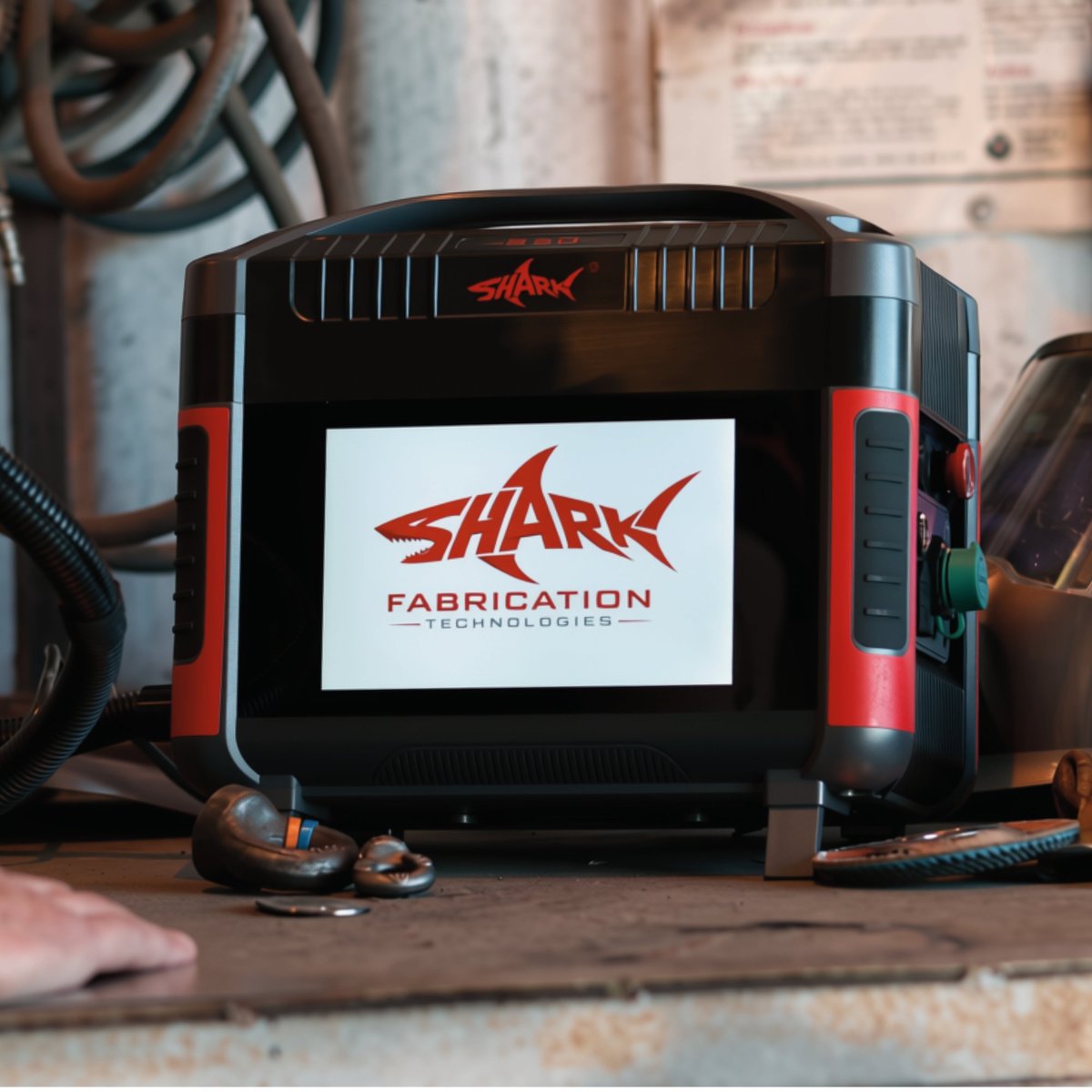 Black and red Shark Fabrication Technologies device with display screen on a work surface