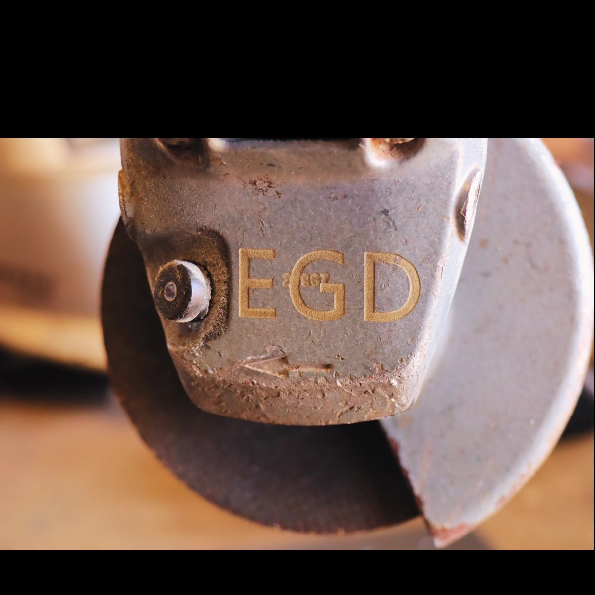 Close-up of a metal horse shoe with OECD text stamped on it, showing weathered surface and metallic shine
