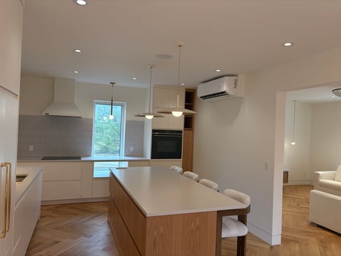 Modern kitchen with white cabinets, wood island, stainless steel appliances, and natural lighting from window