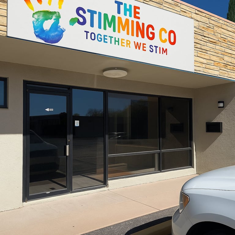 Storefront of The Stimming Co with colorful logo, large glass entrance doors, and tagline Together We Stim on beige building exterior