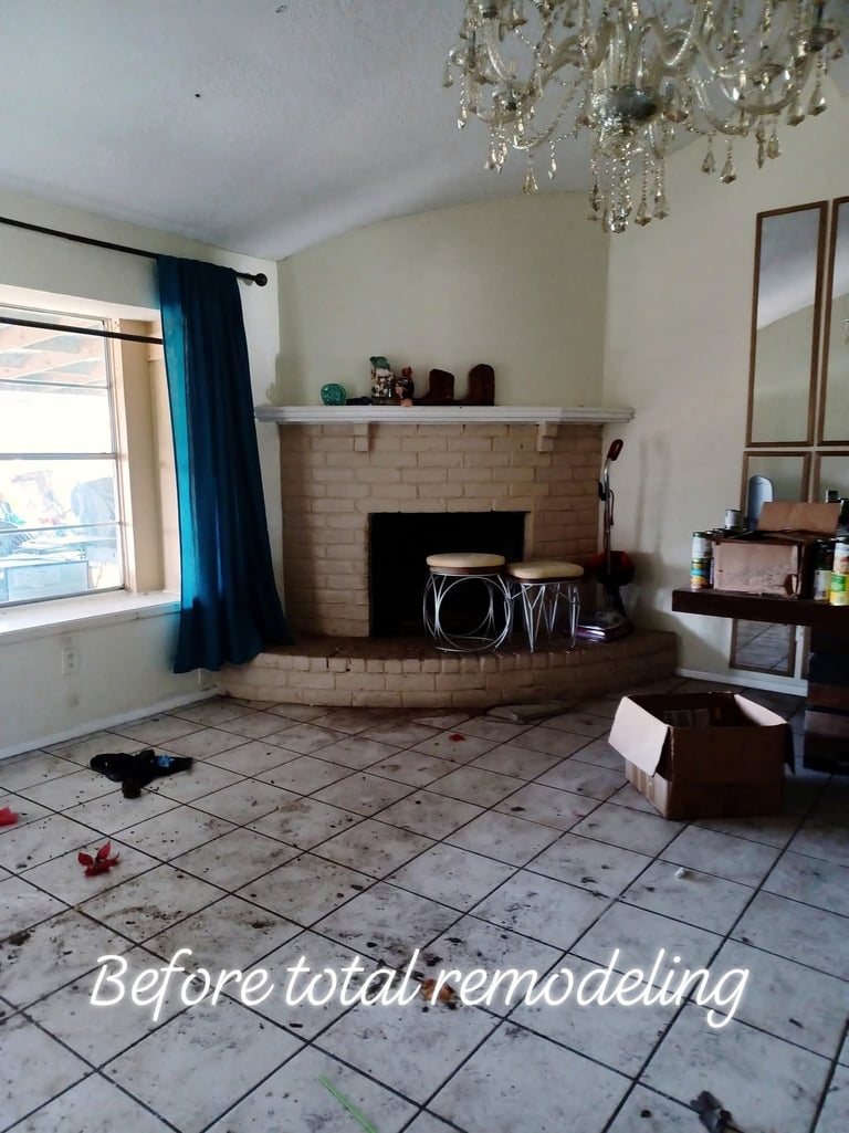 Before total remodeling: Living room with fireplace, tile floor, and blue curtained window awaiting renovation