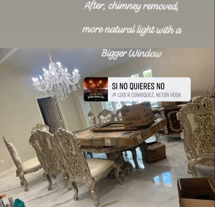 Elegant living room with ornate chairs, piano, crystal chandelier, and larger window after chimney removal allowing more natural light