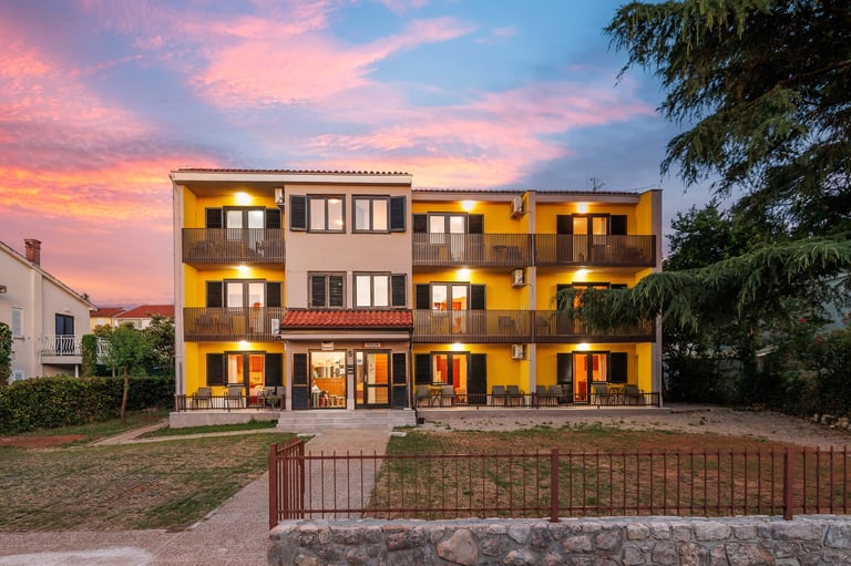 Apartmani u suton s toplom rasvjetom i šarenim zalaskom sunca