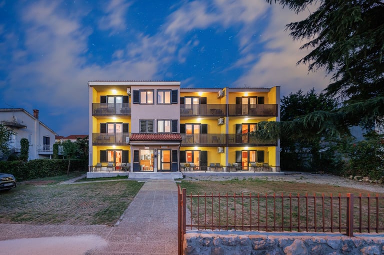MAJA Apartmani u suton s osvijetljenim prozorima