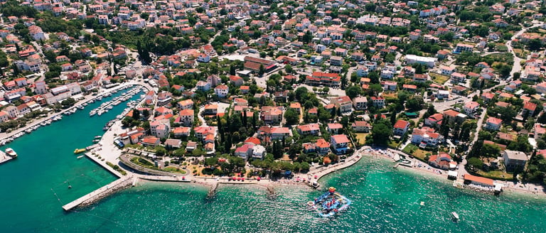 Zračni pogled na primorsko naselje Malinske s pješčanim plažama i tirkiznim morem