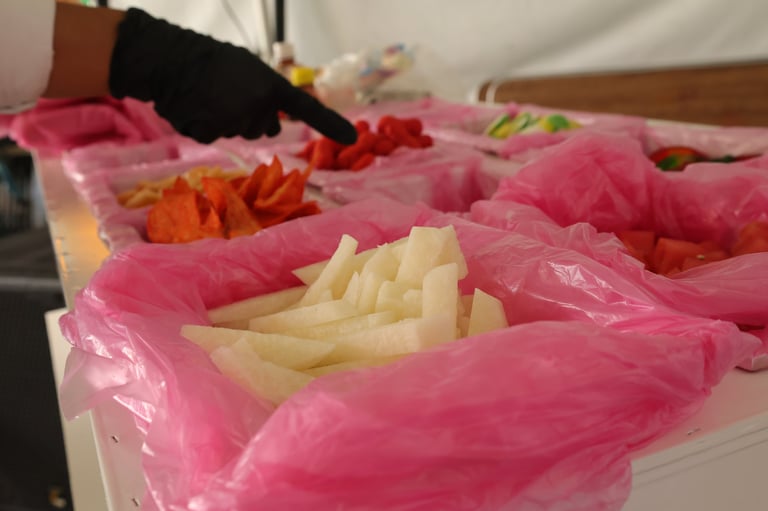 Sorted produce in pink containers including chopped potatoes, red peppers, and other vegetables prepared for cooking