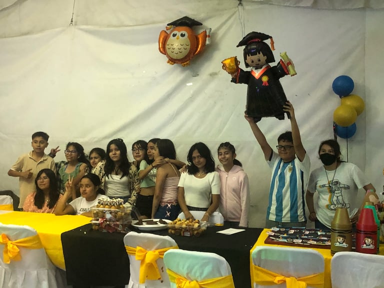 Group of children at an indoor party under a tent with decorations including balloons and hanging ornaments