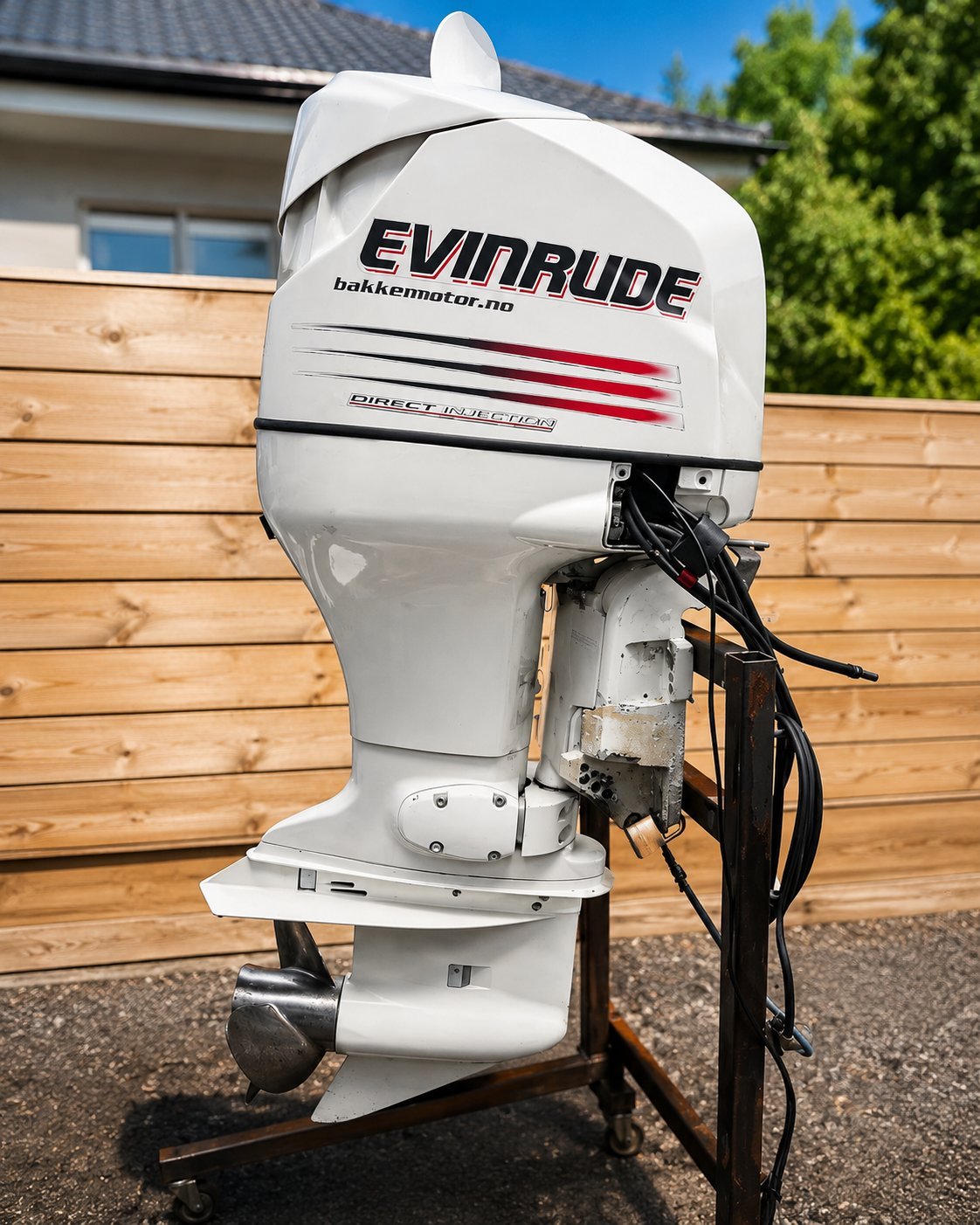 White Evinrude outboard motor mounted on display, showing engine cowl with red stripe detail and power cables.