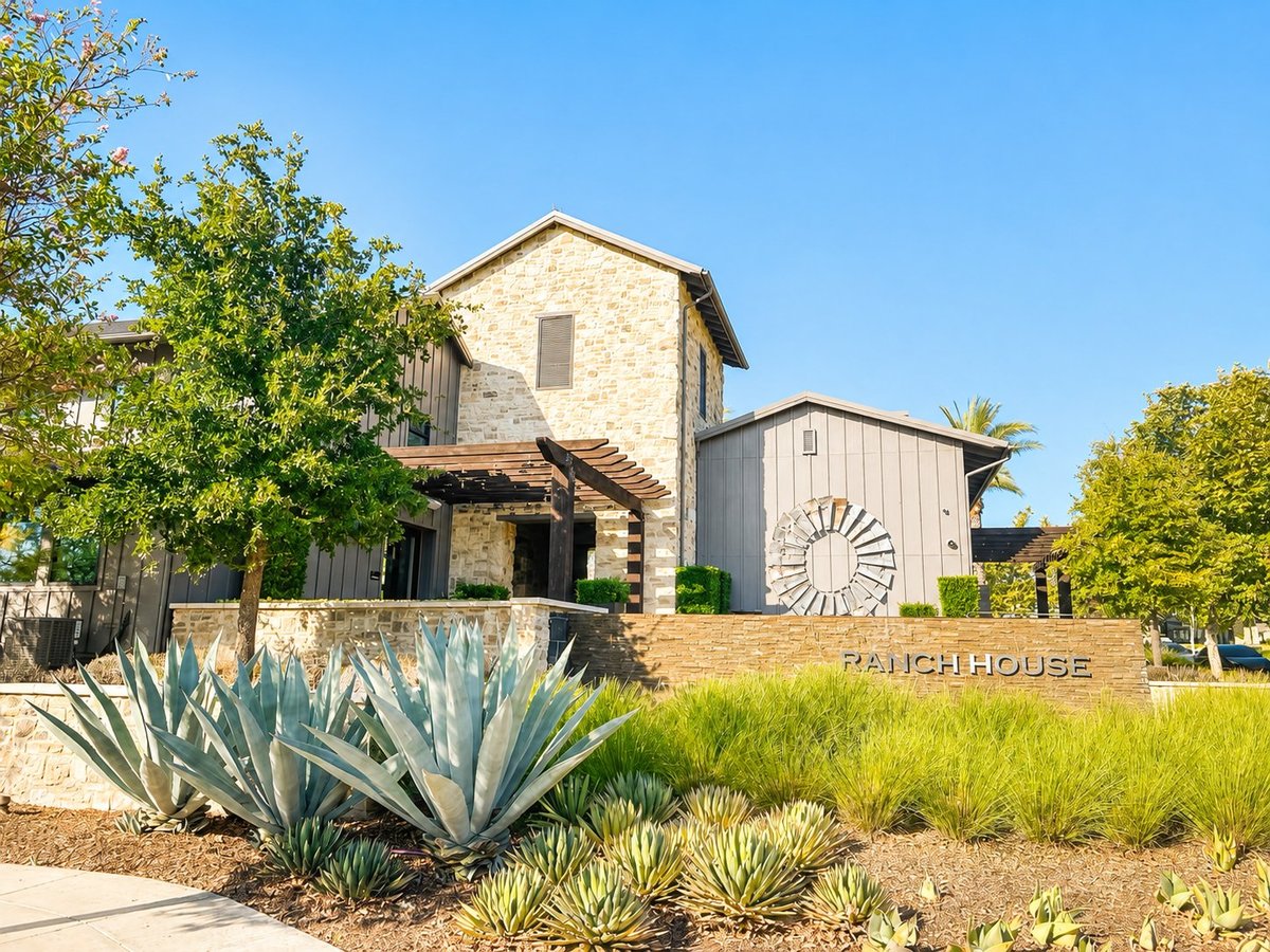 Stone Ranch House clubhouse with agave plants and landscaping, Texas Hill Country style architecture