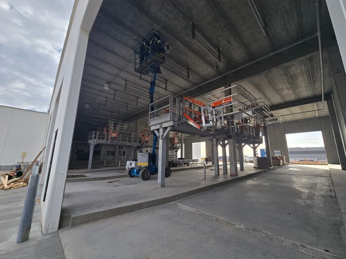 Food processing facility interior with stainless steel processing line, overhead conveyor, and code-compliant electrical installations — CN Electrical food production facility wiring in Chilliwack, BC