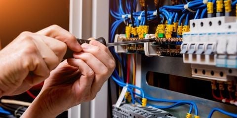 Licensed electrician installing circuit breaker wiring in residential electrical panel — panel upgrade and service change in Hope, BC