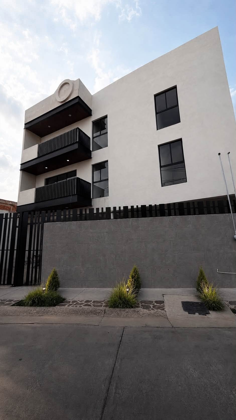 Fachada del edificio moderno de departamentos con balcones negros