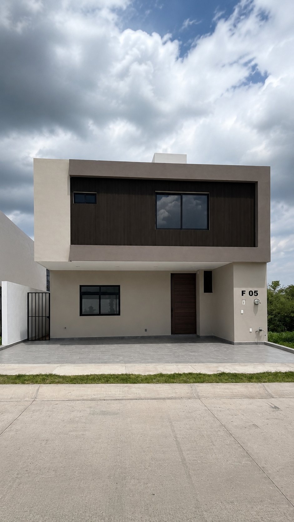Fachada de la casa de dos pisos en color beige y café oscuro con cochera y número F 05