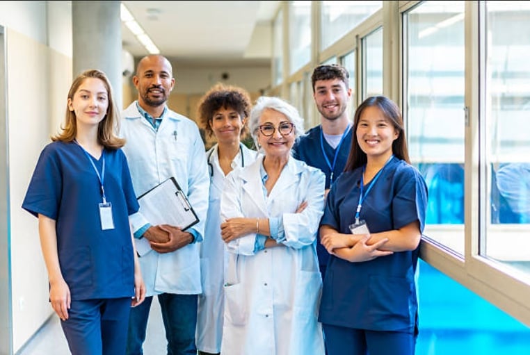 A team of healthcare professionals standing together in a hospital corridor.
