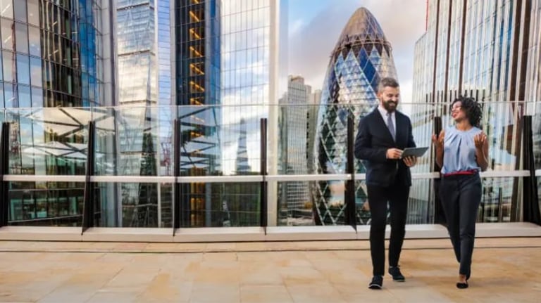 Two business professionals walking through the City of London financial district.