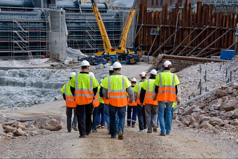 Construction workers in high-visibility clothing on a building site.