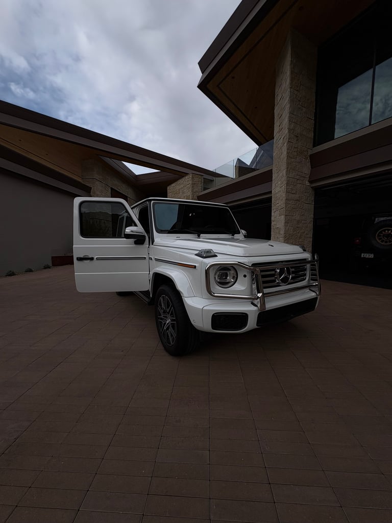 White Mercedes-Benz G-Class with open driver door representing professional mobile detailing service
