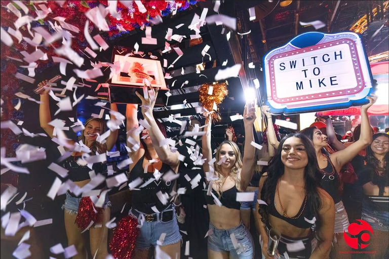 Celebratory scene with confetti falling, people holding a trophy, and a neon Switch to Nike sign visible above the crowd