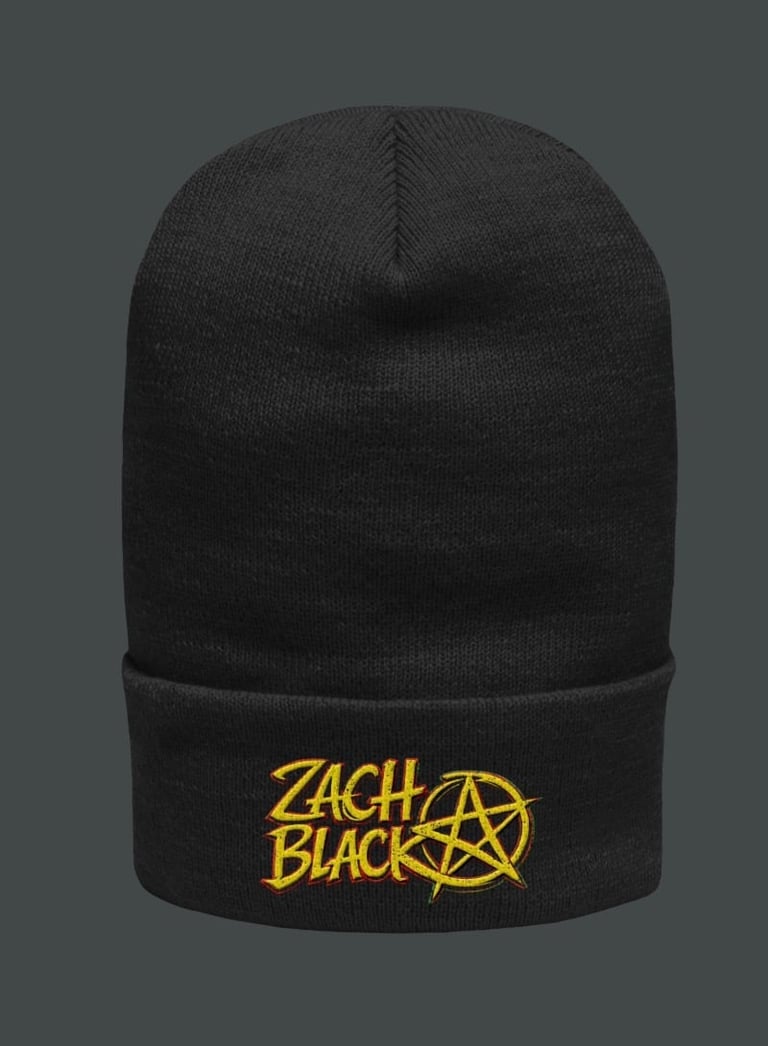 Black knit beanie with yellow Zach Black logo embroidered on cuff against gray background