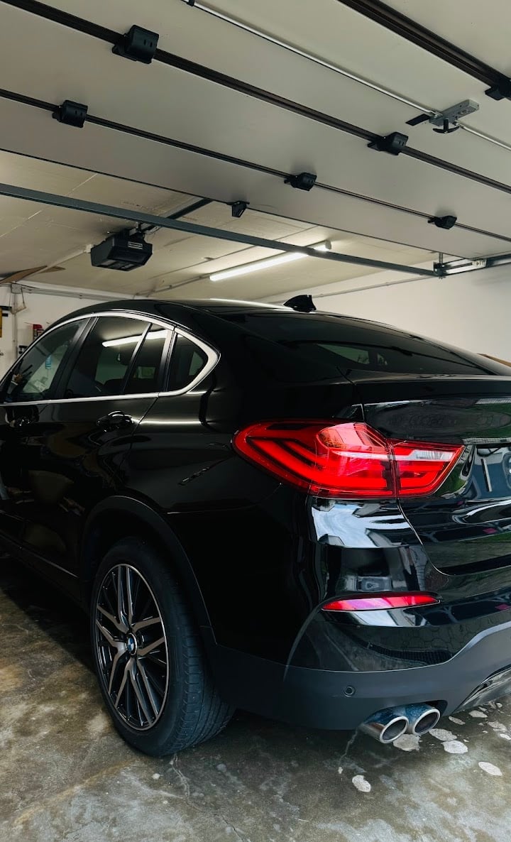 Black luxury sedan in garage with chrome wheels